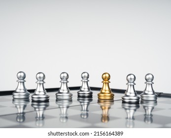 The golden pawn chess piece standing out of the group of silver pawn chess pieces on chessboard on white background, stand out from the crowd. Leadership, Unique, influencer, difference concept. - Shutterstock ID 2156164389
