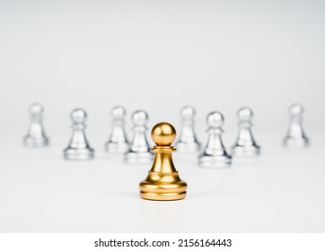 The golden pawn chess piece standing out from the group of silver pawn chess pieces on white background, stand out from the crowd. Leadership, Unique, influencer, difference concept. - Shutterstock ID 2156164443