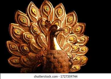 Golden Peacock Statue Isolated On Dark Background.