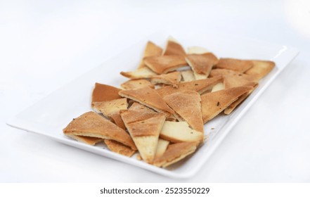  "Golden Pita Chips," presents a simple yet delicious snack. Crispy, golden pita chips are arranged neatly, offering a savory, healthy option that pairs well with dips or can be enjoyed solo. - Powered by Shutterstock