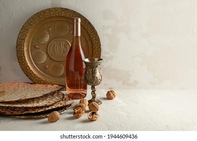 Golden plate for Seder Pesach (Jewish Passover holiday)  (with the inscriptions: egg, shankbone, bitter herbs, lettuce, charoses, parsley) Wine bottle, round matzo on a vintage plate, glass, walnuts. 