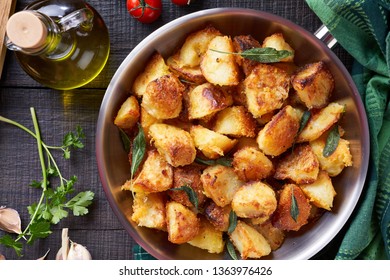 Golden polenta roast potatoes served for the dinner in a metal skillet with sea salt, polenta, garlic, olive oil, parsley, tomato, on a wooden table, view from above, flat lay, close up - Powered by Shutterstock