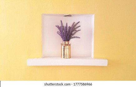 Golden pot with lavander flowers encased in a white square on a yellow wall - interesting architectural detail in interior design