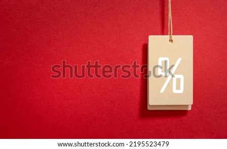 Golden price tag with a percent sign on a red background