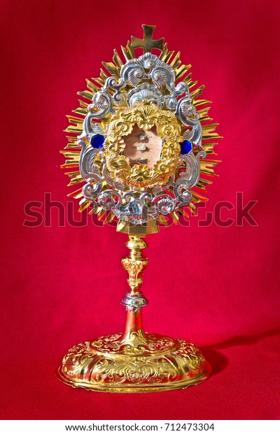 Golden religious equipment  of catholic church\
on red background
