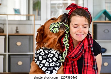   Golden Retriever Dog Kissing A Girl  At Home  With Matching Bandana. Matching Dog And Owner Outfit.