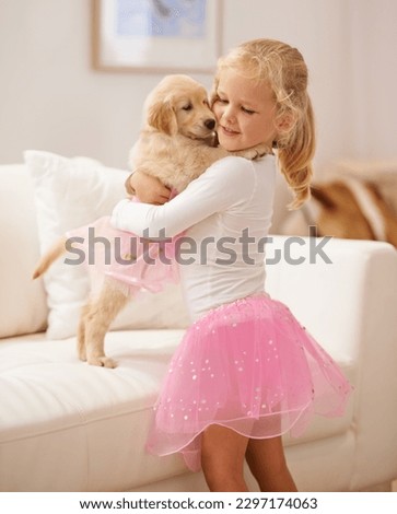 Golden retriever, hug and child happy together with love, care and development. Cute girl kid and animal puppy or pet in a tutu playing dress up as friends on the home sofa with happiness and trust