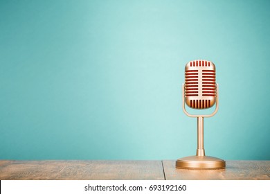 Goldenes Retro-Mikrofon für Pressekonferenz oder Interview auf dem Tisch. Vintage-gefiltertes Foto