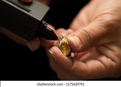 Golden Ring In Hands Ready To Check Real Or Not With Diamond Tester Gemstone Selector Gems LED Indicator Jewelry Kits Test, Portable Electronic Device To Peep Quick, Precise, Safe, Selective Focus