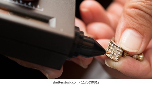 Golden Ring In Hands Ready To Check Real Or Not With Diamond Tester Gemstone Selector Gems LED Indicator Jewelry Kits Test, Portable Electronic Device To Peep Quick, Precise, Safe, Selective Focus