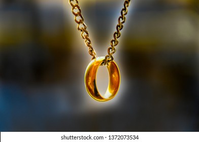 Golden ring hanging from silver chain 