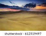 Golden sand dunes at sunrise with ranges of sand hills towards horizon with red sky near Stockon beach , NSW, AUstralia.