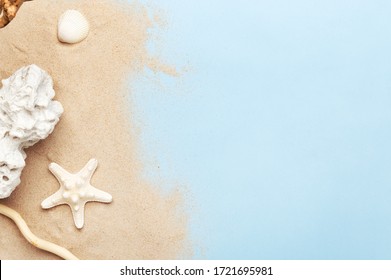 Golden sand and marine decorations. Seashell, starfish and sea stone. Copy space in right side. Isolated blue background. Summer vacation and travel concept