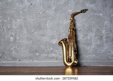 Golden Saxophone On Gray Wall Background