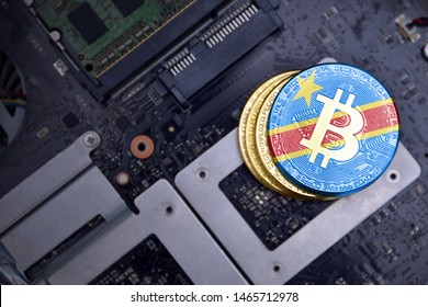 Golden Shining Bitcoins With Flag Of Democratic Republic Of The Congo On A Computer Electronic Circuit Board. Bitcoin Mining Concept.