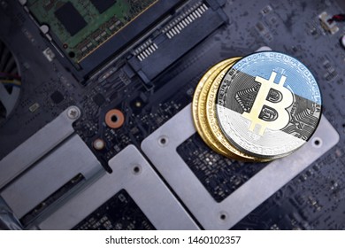 Golden Shining Bitcoins With Flag Of Estonia On A Computer Electronic Circuit Board. Bitcoin Mining Concept.