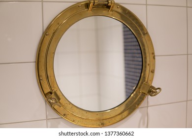 Golden Ship Window Used As Mirror In Bathroom