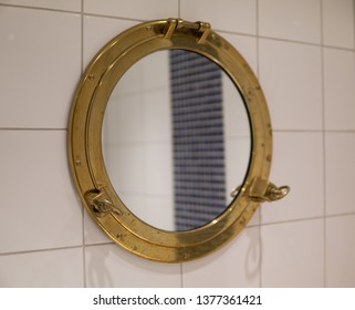 Golden Ship Window Used As Mirror In Bathroom