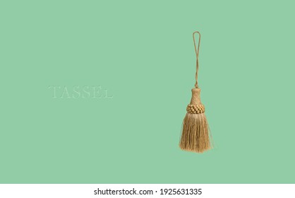Golden silk tassel isolated on green background for creating graphic concepts - Shutterstock ID 1925631335