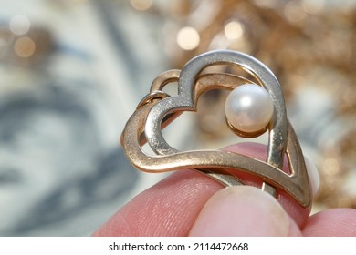 Golden And Silver Pendant With Pearl Shaped Heart On Money And Jewelry Background, Pawnshop Concept, Jewerly Shop Concept, Closeup