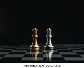 Golden and silver queen chess pieces standing together on a chessboard on dark background. Leader, team, enemy, cooperation, partnership, and business strategy concept.