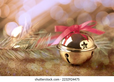 Golden sleigh bells and fir branches on table, closeup - Powered by Shutterstock