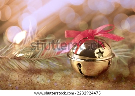 Golden sleigh bells and fir branches on table, closeup