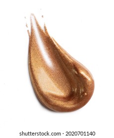 Golden smear of highlighter on white background. Creamy texture of rich shimmery cosmetic product. 