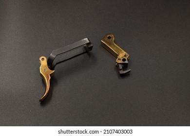 Golden Spare Parts For A Pistol On A Black Background