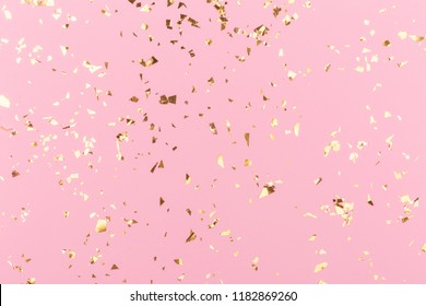 Golden sparkles on pink pastel trendy background. Festive backdrop for your projects.