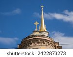 golden spire, golden orthodox cross on gold dome on blue sky. close-up