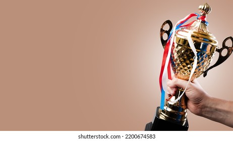 Golden Sports Cup And Medals On Multi-colored Ribbons On The Cup. Award For Sporting Achievements, Success, Victory, Holiday. There Are No People In The Photo. There Is Free Space To Insert.