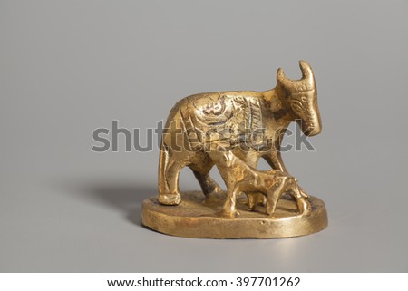 Golden statue cow and calf  on gray background