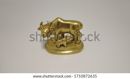 Golden statue of a cow in white background