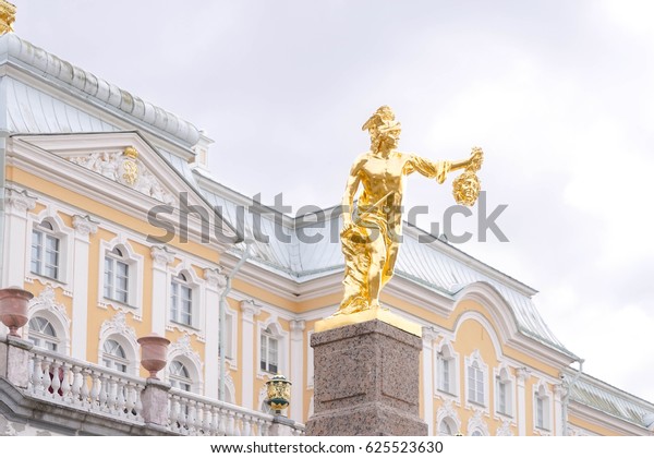 Golden statue of Greek and Roman god of\
communication Mecury carring a Medusa head, Peterhof Palace, St.\
Petersburg, Russia