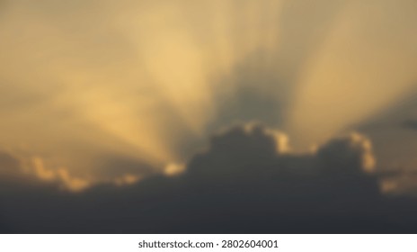 Golden sun rays dramatically pierce through dark, silhouetted clouds during a vibrant sunset, creating a powerful atmospheric effect.
