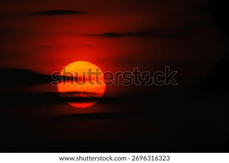 Golden sun setting through dramatic clouds at dusk, spreading warm light across the sky — a serene and spiritual moment symbolizing peace, transition, and divine energy.