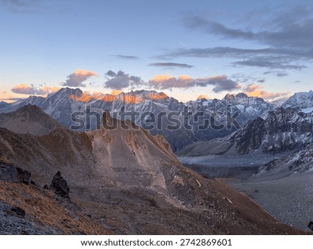 Golden sunset casting warm light over the Arolla Valley, viewed from Col de Riedmatten in the Swiss Alps.