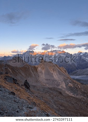 Golden sunset casting warm light over the Arolla Valley, viewed from Col de Riedmatten in the Swiss Alps.