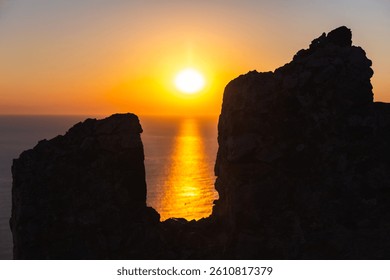 Golden sunset radiating through the silhouette of ancient stone ruins, reflecting warmly over tranquil sea waters, Alanya Kale fortress, Turkey
