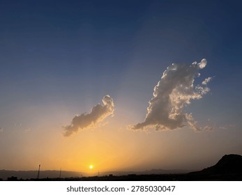 Golden Sunset Sky with Dramatic Cloud Formation Over Mountain Silhouette Landscape