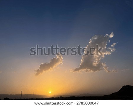 Golden Sunset Sky with Dramatic Cloud Formation Over Mountain Silhouette Landscape