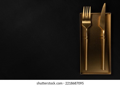 The golden tableware is placed on a Golden Tray. The background is black leather. Luxurious, sumptuous fine tableware.Flat lay, top view, banner,horizontal photo - Shutterstock ID 2218687095