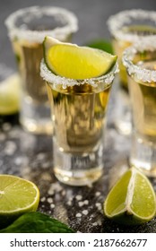 Golden Tequila shots served with lime and sea salt on table