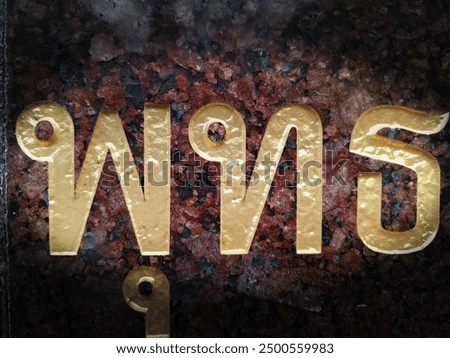 Golden Thai script on a dark, textured background.