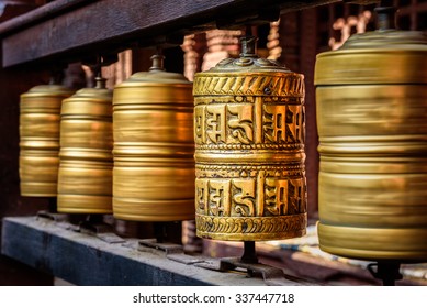 Golden tibetan prayer wheels in a Buddhist temple in Nepal