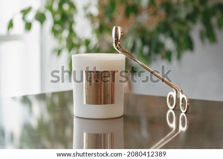 Golden Trimmer Candle Wick Scissors And Wax Candle On The Table in the Living Room