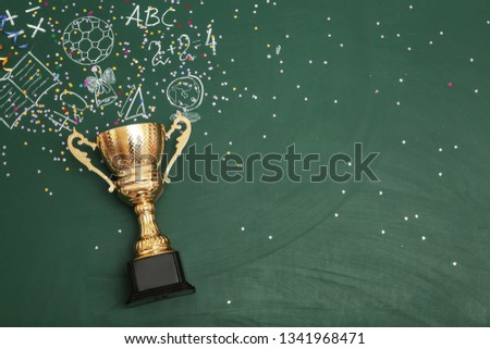 Golden trophy cup and chalk drawings on color background, top view with space for text