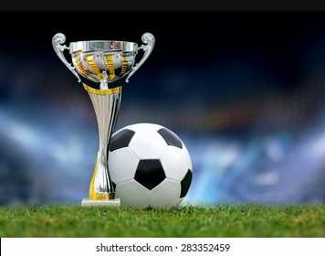 Golden Trophy In Grass On Soccer Field Background