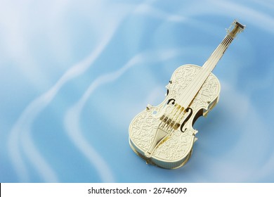 Golden violin on rippled water background
